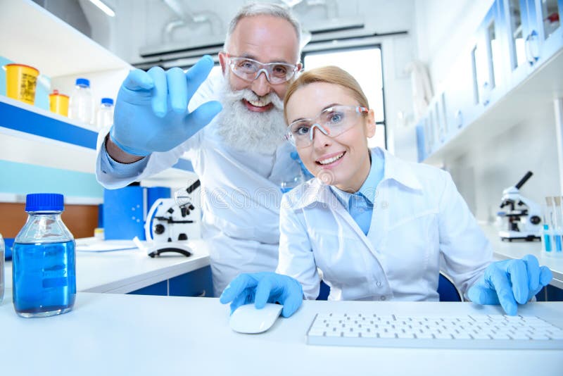工作与计算机老鼠和键盘一起的成熟科学家在实验室. 化学制品, 欧洲.