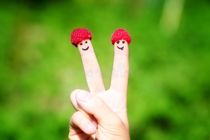 愉快的夫妇手指用莓和被绘的微笑