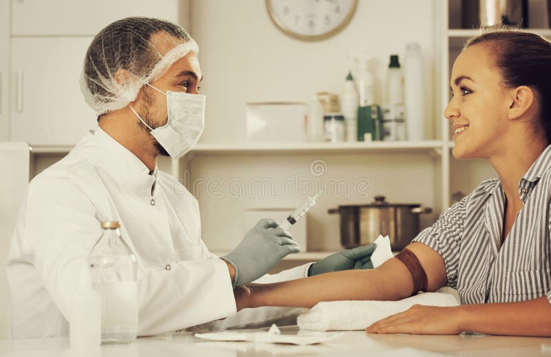 Enfermera De Sexo Masculino Que Inyecta Al Paciente Femenino Foto De