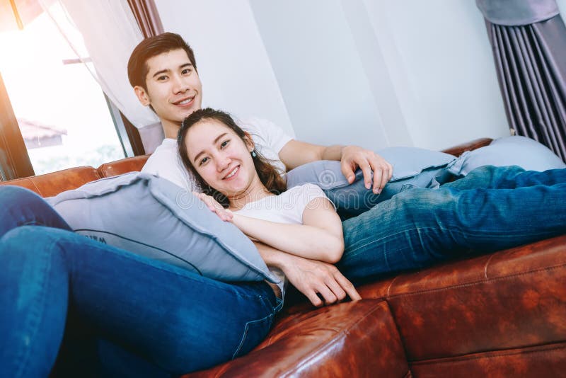 一起看电视的亚洲青少年的夫妇愉快地.