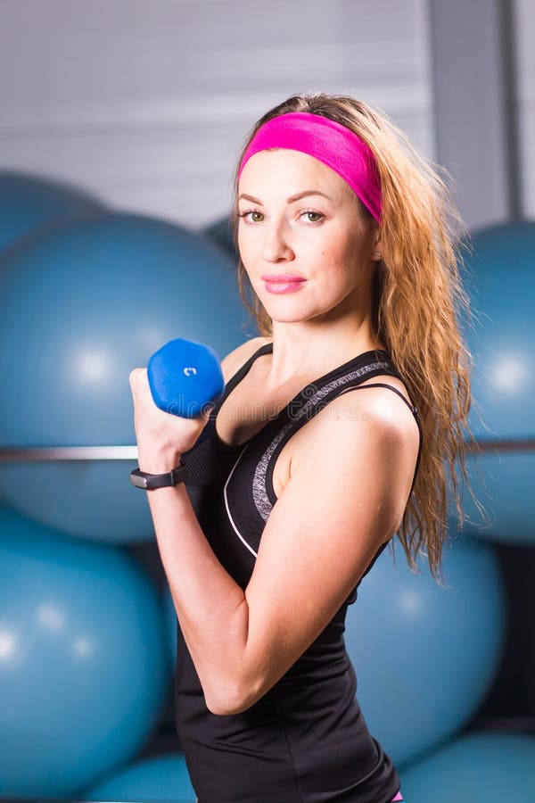 健身与哑铃的妇女锻炼. 白种人, 顶楼.
