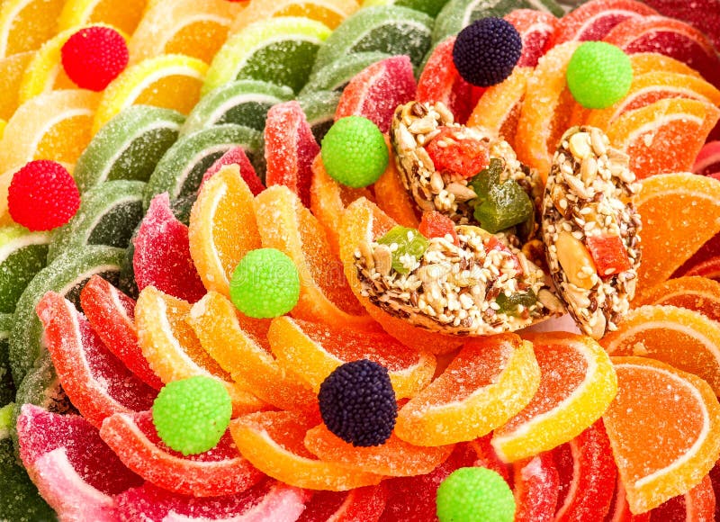 五颜六色的含糖的橘子果酱喜欢柠檬和橙色切片用手工制造棒棒糖糖果