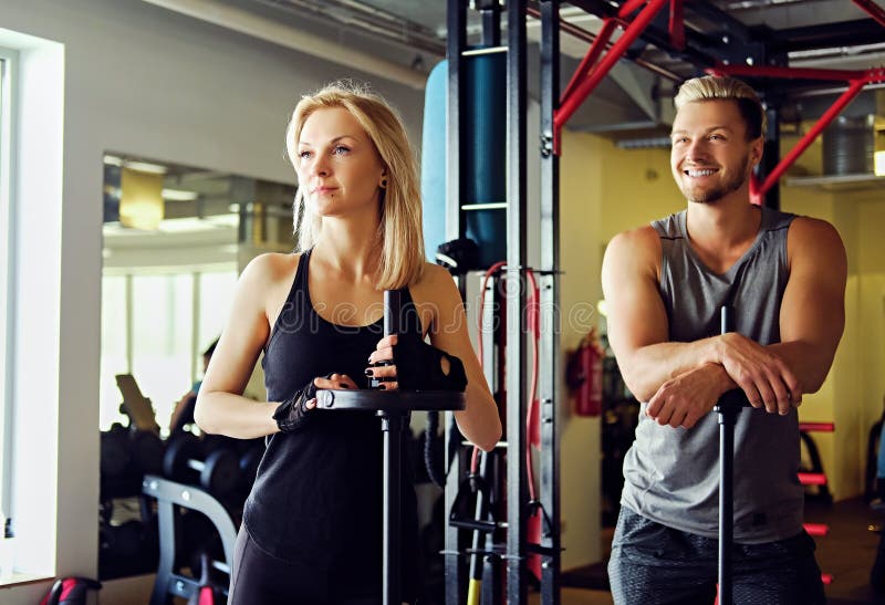 肌肉男在健身房里用哑铃锻炼身体.