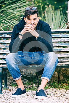 Boyfriend waiting. Handsome young man model sitting on the bench