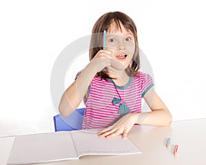 Child writing at desk gets an idea