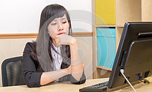 Chinese businesswoman at desk looking at monitor