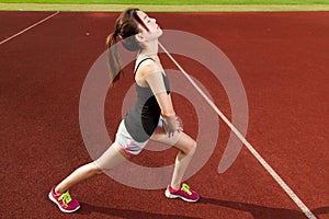 Chinese female athlete stretching legs on sports f