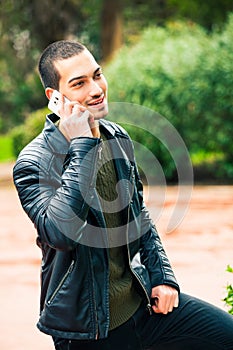 Happy young man with smartphone. Talking on the phone.
