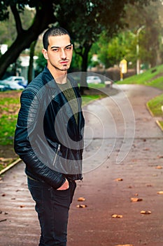 Portrait of young beautiful man outdoors, path in the park