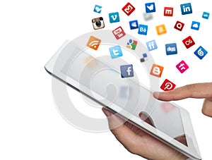 Social media icons fly off the ipad in hand