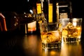Barman pouring whiskey in front of bottles, focus on top of bottle
