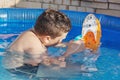 Boy plays with boat in the pool