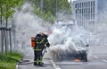 Burning motor vehicle been put out by firemen in protective clot freiburg germany june firefighters are just putting a and smoking Stock Images