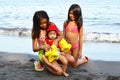 Child safety two young girls helping their baby sister to wear arms band Stock Photography
