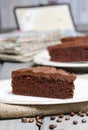 Chocolate cake on white plate, on hessian