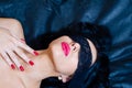 Closeup image of blindfold young beautiful sexy brunette woman with red lipstick, nails eyes covered in lace band