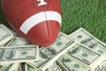 College style football on field with a pile of money