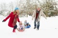 Family Pulling Sledge Through Snow