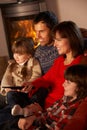 Family Relaxing Watching TV By Cosy Log Fire