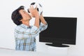 Football fan kissing ball against tv