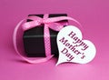Gift with pink polka dot ribbon and white heart shape gift tag with Happy Mothers Day