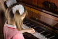 The girl learns to play a piano