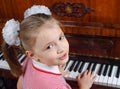 The girl learns to play a piano