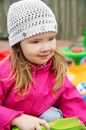 Girl playing to a sandbox with shovel