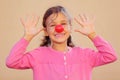 Girl with red clown nose smiles