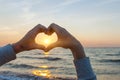 Hands In Heart Shape Framing Sun