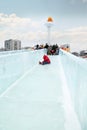 Little girl in red rolls to ice slide in Ice town
