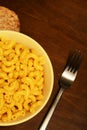 Mac and cheese with fork on wooden table