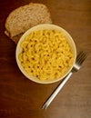 Mac and cheese with whole grain bread on wood background