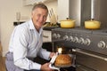 Man Taking Food Out Of The Oven