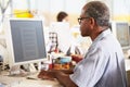 Man Working At Desk In Busy Cr...
