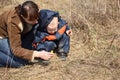 Mother with child look on first flower in spring