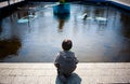 Old deserted playground lonely child looking at broken toys in an Stock Images