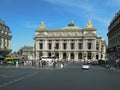 Palais garnier paris the golden statues of the famous opera house in glisten in the sunlight across a busy square Stock Photos