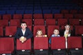 Parents with son and daughter watching a movie