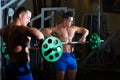 Pumped guy picking up heavy barbell