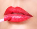 Red Lipstick. Lip Gloss on Sexy Lips and Brush.