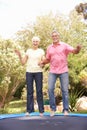 Senior Couple Jumping On Tramp...