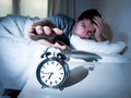 Sleeping man disturbed by alarm clock early mornin
