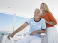 Smiling Couple At Helm Of Yacht