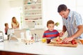 Son Helping Father To Prepare Family Breakfast In Kitchen