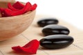 Spa stones and rose petals in bowl isolated