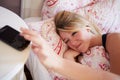 Teenage Girl Waking Up In Bed And Turning Off Alarm On Phone