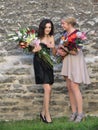Unidentified girls with flower bouquets tallinn june striking a pose for a photograph one of them is adjusting her dress in Royalty Free Stock Photography
