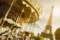 Vintage carousel close to Eiffel Tower, Paris with sun flare effect