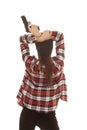 Woman in beanie and plaid shirt back gun